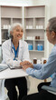 © MrAshi - Asian female doctor and patient talking about something while sitting at the table, female doctor wearing white uniform and a stethoscope is checking the condition of an elderly male patient.