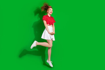 Poster - Full length photo of lovely young lady charming jumping dressed stylish red retro garment isolated on green color background