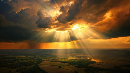 Sticker - Spectacular God rays emerging from behind dark storm clouds, illuminating a vast countryside with a golden glow