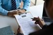 © Wasan - Job interviews, Employer in suit reading resume of job interview candidate profile collection. Man explaining profile to a manager sitting for a job interview. Job Search and Human Resources