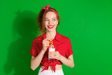 Poster - Photo portrait of attractive young woman look empty space milk glass dressed stylish red retro clothes isolated on green color background