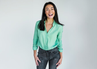 Wall Mural - 40s latina woman is smiling and wearing a green shirt and black pants, isolated on white 