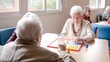 © DMegias - Senior woman playing ludo with friends at table in nursing home
