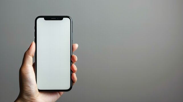 A minimalist image showing hands holding a smartphone with a blank screen against a blue background. This clean and simple composition highlights modern technology and potential customization