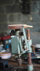 Dusty old Bench Hand Drill on a workshop table