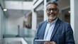 © Bijac - smiling middleaged indian ceo using tablet in office professional business portrait