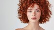 © MD Media - A model with curly red hair in an elegant and modern short hairstyle, posing for the camera against a white background. Close-up smiling brunette model with long, curly red hair and glamorous makeup