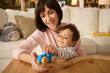 © Stockphotodirectors - Cute little boy and his mother playing with wooden train at home