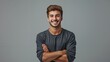 © MD Media - A handsome young man smiling with his arms crossed against a grey background, wearing casual with a confident and happy expression in a studio portrait.