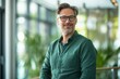 © FR-Studio - Portrait of a smiling middle-aged business man employee wearing a green shirt and glasses