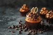 © Ibraheem - A cupcake with a number 40 candle, surrounded by chocolate chips, on a solid dark dark chocolate background.