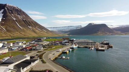 Wall Mural - Aerial view of Isafjordur (Ísafjörður) and the harbour, Iceland, colorful buildings, sea, fjord, moutains with snow. Arctic climate, bright light. Polar climate. Westfjords region.