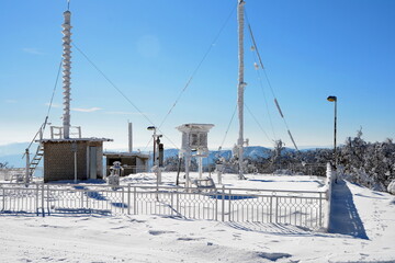 An ice-covered screen weather station, high on a mountain