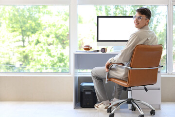 Wall Mural - Young man sitting near desk at home