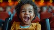 © familymedia - Happy toddler laughing and enjoying herself in a movie theater seat