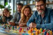 © GreenOptix - some employees play the board game during a team building activity in the office
