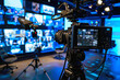 © Cadengo - A broadcast studio with 3 seperate LED wall displaying a video conference call with fifty professionals and the main speaker before the LED wall with a camera on a tripod directed