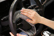 © New Africa - Woman cleaning steering wheel with rag in car, closeup