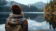 © kitipol - A content traveler gazes out at the still waters of a peaceful lake, their expression radiating warmth and serenity, with the tranquil setting offering a moment of respite from the hustle and bustle