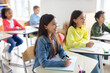 © Home-stock - In classroom smart European girl carefully listening teacher during lesson, group of bright children learning, sitting at desks