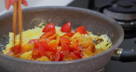 Canvas Print - Cooking the tomato with egg in the kitchen