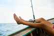 © C Pendl�/peopleimages.com - Man, feet and boat for fishing in ocean with relax, vacation with water activity for wellness. Male person, legs up and sea with casting break on ship, nature with recreation or freedom in Brazil