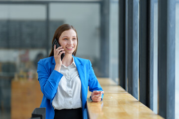 African businesswoman American uses smartphone while working on laptop at office Businesswoman working on the phone online applications Success concept, relaxation, online ordering.