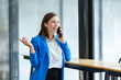 © crizzystudio - African businesswoman American uses smartphone while working on laptop at office Businesswoman working on the phone online applications Success concept, relaxation, online ordering.