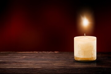 Poster - A lit candle with bright flame on dark background