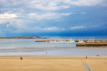 Canvas Print - View at the harbour with boats och en sandstrand and a thunderstorm out on the sea