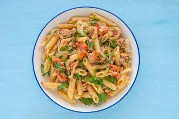 Wall Mural - Tuna Pasta in ceramic bowl over blue wooden background.