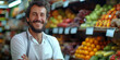 © visoot - Happy smiling caucasian sales man with white work apron in front of a shop gross market, salesman. Generative AI.
