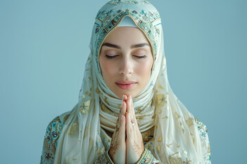 A successful beautiful Muslim business woman with a fit physique, dressed in traditional attire, in a prayer pose, with a light blue background