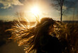 © Cavan Images - Young girl flipping long blonde hair in sunny field