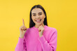 © Ivan - Positive brunette woman points above shows place for your advertising text smiles pleasantly isolated over yellow background. Great idea cool offer
