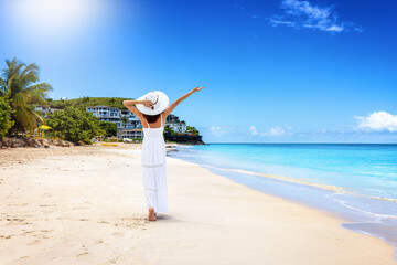 Sticker - A happy woman in a white summer dress walks along the beautiful Darkwood beach at the Caribbean island of Antigua