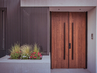 Wall Mural - A modern design house entrance with a wooden door, black fence and colorful flowers. Travel to Athens, Greece.