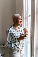 Poster - Happy woman with cell phone and coffee cup looking out of window