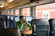 © tunedin - Man sitting in train holding tablet