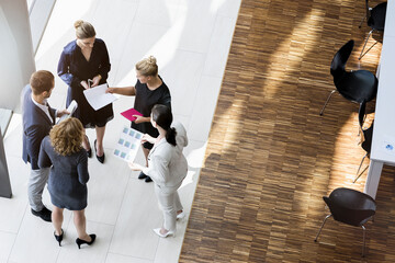 Sticker - Business people standing in modern office building discussing project