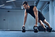 © tunedin - Man doing pushups on kettlebells at gym