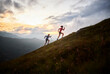 © tunedin - Man and woman running uphill in the mountains