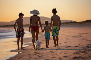 Sticker - Happy children, boys, playing on the beach on sunset, kid cover in sand, smiling, laughing