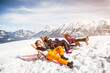 © tunedin - Friends sunbathing in deck chairs in mountainscape in winter, Achenkirch, Austria
