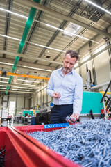 Canvas Print - Man in factory examining shred in container