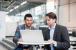 © tunedin - Two businessmen sharing laptop in factory