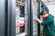 © tunedin - Teenager working with cables in server room