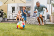 © tunedin - Father and son playing football in garden