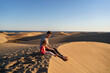 © tunedin - Father and daughter sitting on sand dune, Gran Canaria, Spain