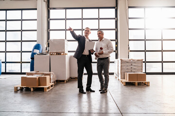 Wall Mural - Two businessmen talking in a factory